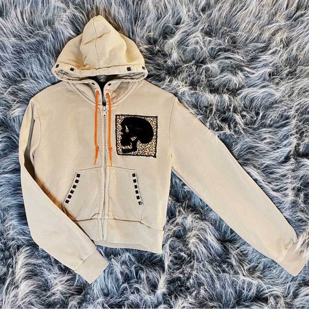 Beige distressed crop hoodie with custom designed skull patch.